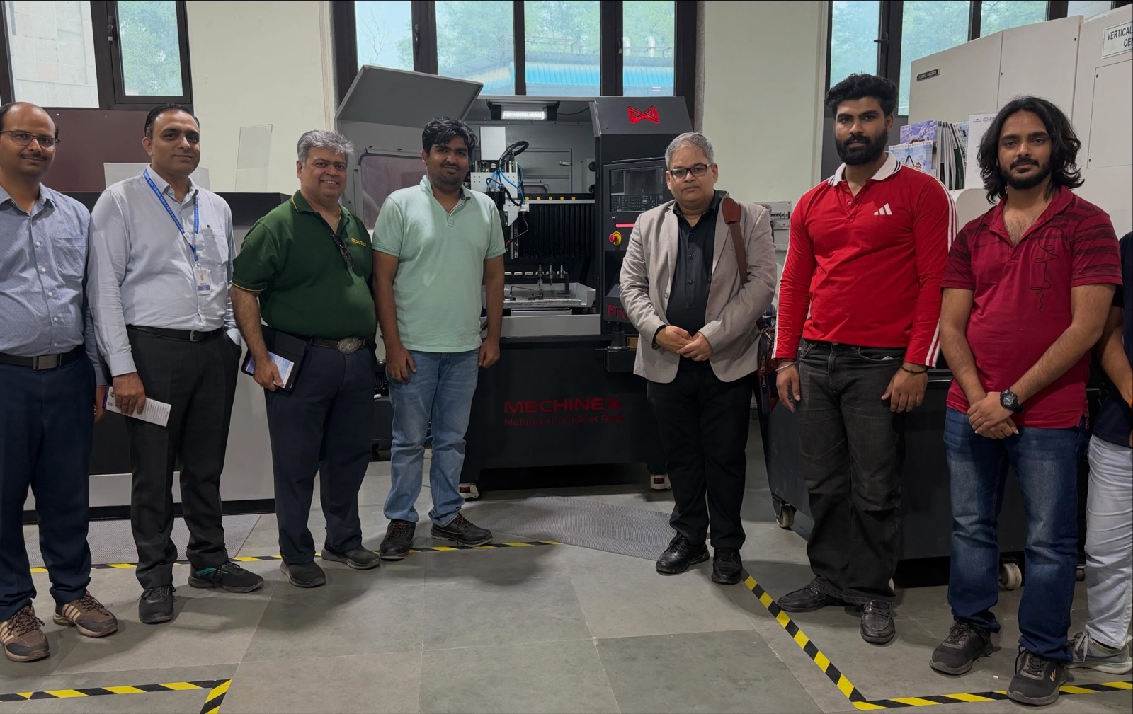 DEI team with IHFC staff beside a CNC machining centre at the mPragati Centre, IIT Delhi