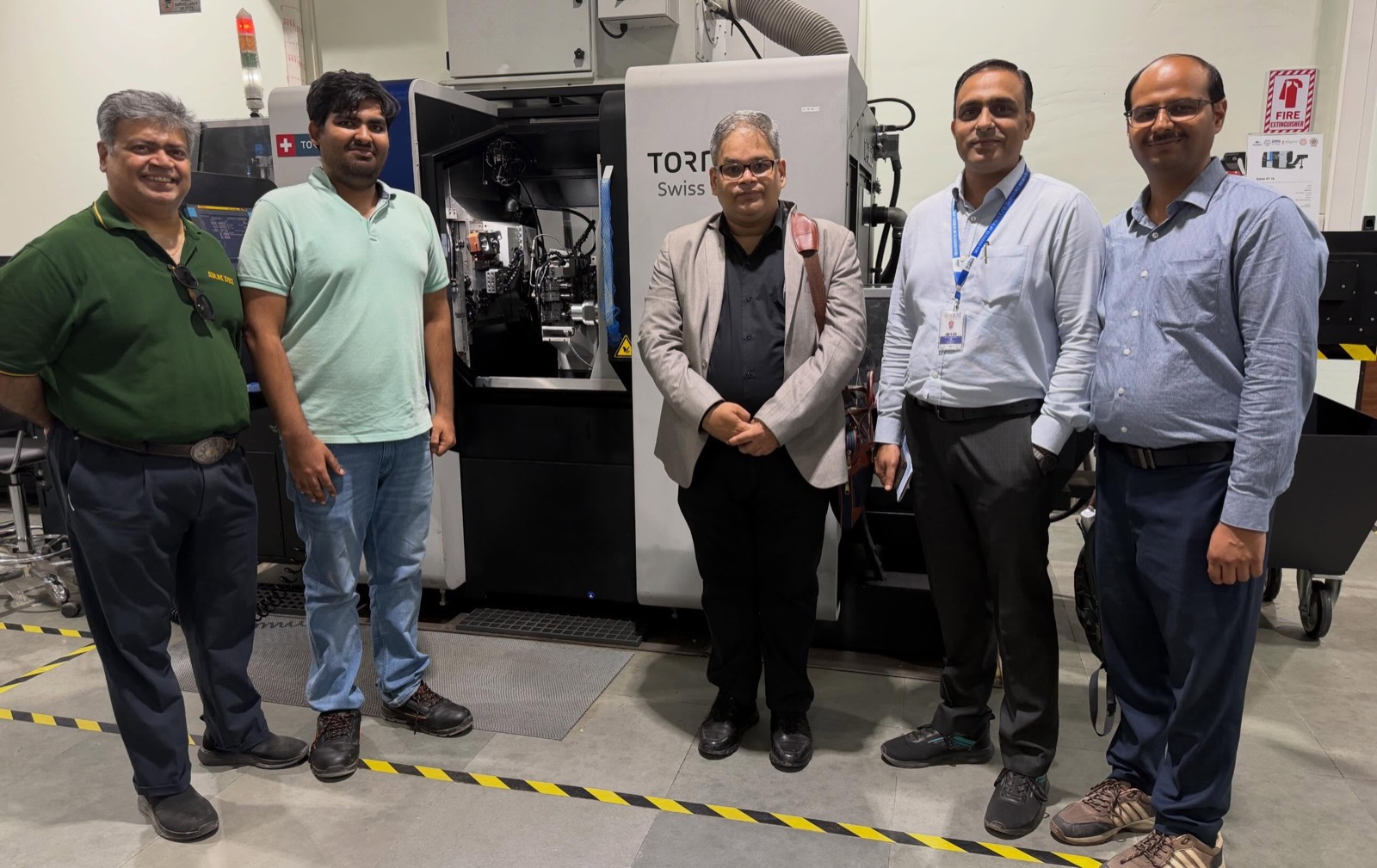 Dr. Shantanu Patil and the DEI team at a Tornos Swiss-type precision lathe during the IHFC visit